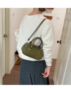 Green woven shoulder bag for women, retro bowling style handbag with top handle and strap.