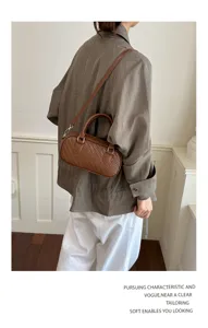 Detailed view of the brown woven texture shoulder bag, featuring a chic cylindrical daily style.