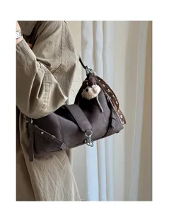 Detailansicht der dunkelbraunen Retro-Umhängetasche mit Plüschtier und elegantem Gurt.