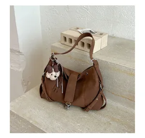 Retrobraune Schultertasche Detail, stilvolle Achseltasche mit niedlichem Welpen-Anhänger.