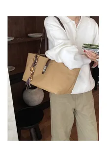 Retro canvas shoulder bag with brown leather strap, twist lock and chic tassel charm.