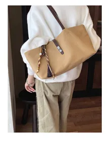 Detailed view of casual canvas tote bag with tassel charm, perfect everyday shoulder bag.
