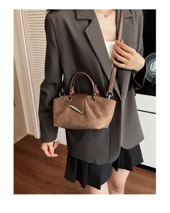 Retro brown suede shoulder bag detail view, stylish knotted handle women handbag on model.