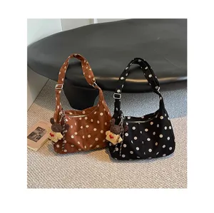 Detailed view of the retro suede polka dot shoulder bag, featuring a cute plush bear charm.