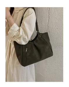 Close-up detail of women's underarm shoulder bag with zipper pocket and stylish rivet design.