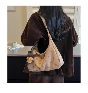 Detail view of retro polka dot suede underarm shoulder bag with cute bear charm for daily wear.