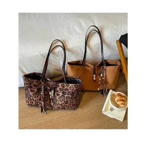 Vista detallada de bolsos tote grandes de ante, con estampado de leopardo y marrón.