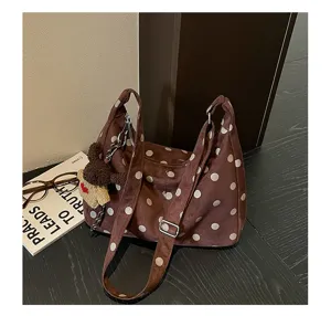 Detailed view of vintage brown polka dot suede shoulder bag, spacious and stylish for autumn.