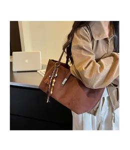Bolso tote retro informal de gran capacidad para mujer en ante con detalle de borlas.