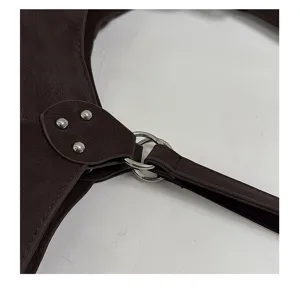 Dark brown leather shoulder bag detail, metallic ring hardware and rivet connection close-up.