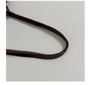 Detail shot of dark brown leather shoulder bag strap with fine stitching and quality.