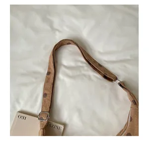 Brown suede polka dot shoulder bag strap detail, vintage autumn underarm bag close up view.