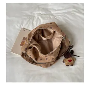 Brown suede polka dot underarm bag detail, slouchy tote design with inner pocket and cute bear.
