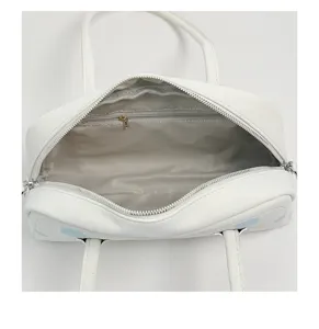Vista de detalle interior del bolso bowling blanco, bolso minimalista con lunares.