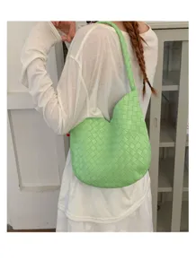 Detailed view of the woven shoulder bag worn by a model, showcasing texture and elegant style.