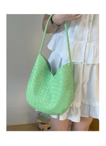 Close-up detail of the bright green woven shoulder bag showing exquisite craftsmanship.