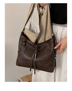 Detailed view of brown woven shoulder bag with chic retro design, perfect for daily use.