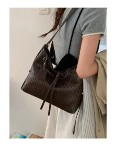Retro brown woven shoulder bag for women, stylish underarm bag with vintage design.