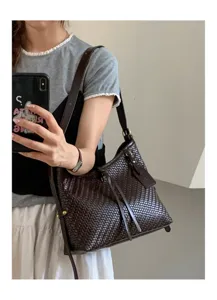 Woven leather shoulder bag detail shot, dark brown hobo style with delicate texture and strap.