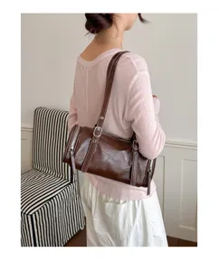 Detalle de bolso de hombro marrón retro, elegante bolso de almohada cilíndrico para mujer.