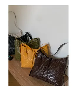 Woven leather shoulder bag for women, vintage underarm handbag, stylish woven bucket bag design.