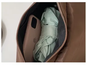 Detail view of brown nylon underarm bag interior showing spacious capacity for phone and umbrella.