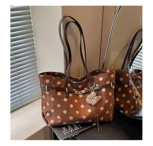 Detail view of the brown suede polka dot tote bag, featuring chic straps and charm.
