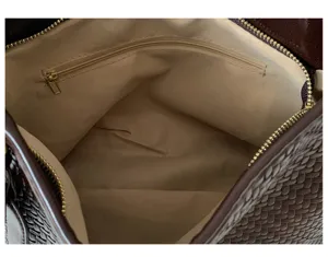 Detailed interior view of a brown woven leather shoulder bag with soft fabric lining.