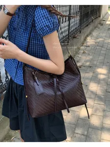 Retro brown woven bucket bag for women, stylish niche design shoulder handbag for daily wear.