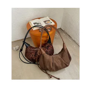Retro suede and leopard print underarm hobo bags showcased in a cozy styled corner detail.