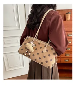 Women suede shoulder bag with chic polka dots and cute bear pendant for daily commute style.