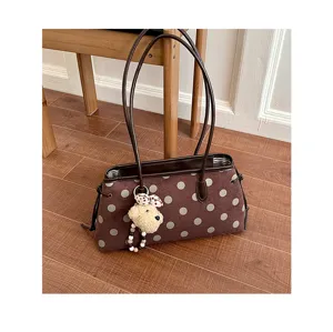 Chic brown suede shoulder bag with large polka dots, double straps, and cute plush pendant.