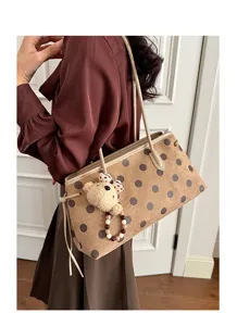 Close-up detail of the vintage suede shoulder bag with chic polka dot print and cute bear charm.