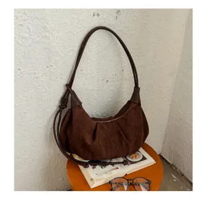Detail shot of retro brown suede hobo shoulder bag, showing soft texture and elegant curves.