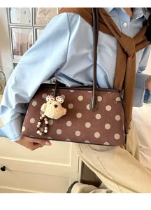 Close-up detail of the brown polka dot suede shoulder bag featuring a cute bear charm.