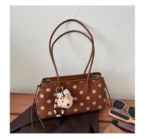 Brown polka dot suede shoulder bag detail, cute bear plush keychain and dual straps style.