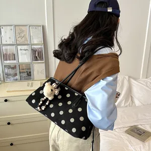 Chic suede polka dot shoulder bag for women, stylish commuting underarm tote with bear charm.