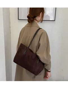 Retro suede shoulder bag detail view, showing the soft dark brown texture and slim strap.