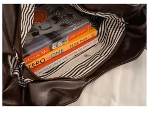 Detailed interior view of a brown suede tote bag showcasing large capacity and striped lining.