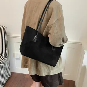 Black suede shoulder bag for women, large capacity minimalist tote bag worn on back view.