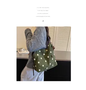 Detailed view of retro green suede shoulder bag with cute white pom poms for daily wear.