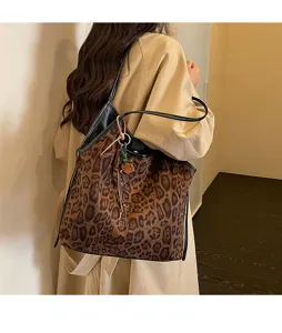 Chic leopard print shoulder tote bag with plush suede texture and elegant black handles, detail view.