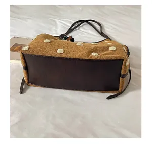 Retro plush polka dot suede shoulder bag with brown leather bottom and chic fluffy dots design.