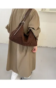Vue détaillée du sac porté épaule en suédine marron mettant en valeur sa texture et sa taille.