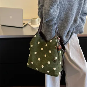 Retro green suede tote bag for women with fluffy white polka dots and chic brown leather handles.