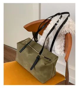 Retro olive green shoulder bag detail shot showing smooth suede texture and metallic zipper.