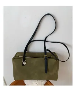 Retro suede shoulder pillow bag with black straps and heart charm, casual commuter detail.