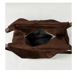 Vue détaillée du sac cabas en suédine marron, montrant l'intérieur spacieux et la fermeture.