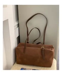 Vintage brown suede shoulder bag for women, casual commuter pillow bag with metal buckles.
