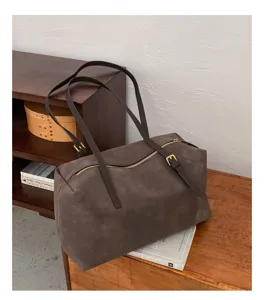 Detail view of the vintage brown suede pillow shoulder bag, highlighting the zipper and double straps.